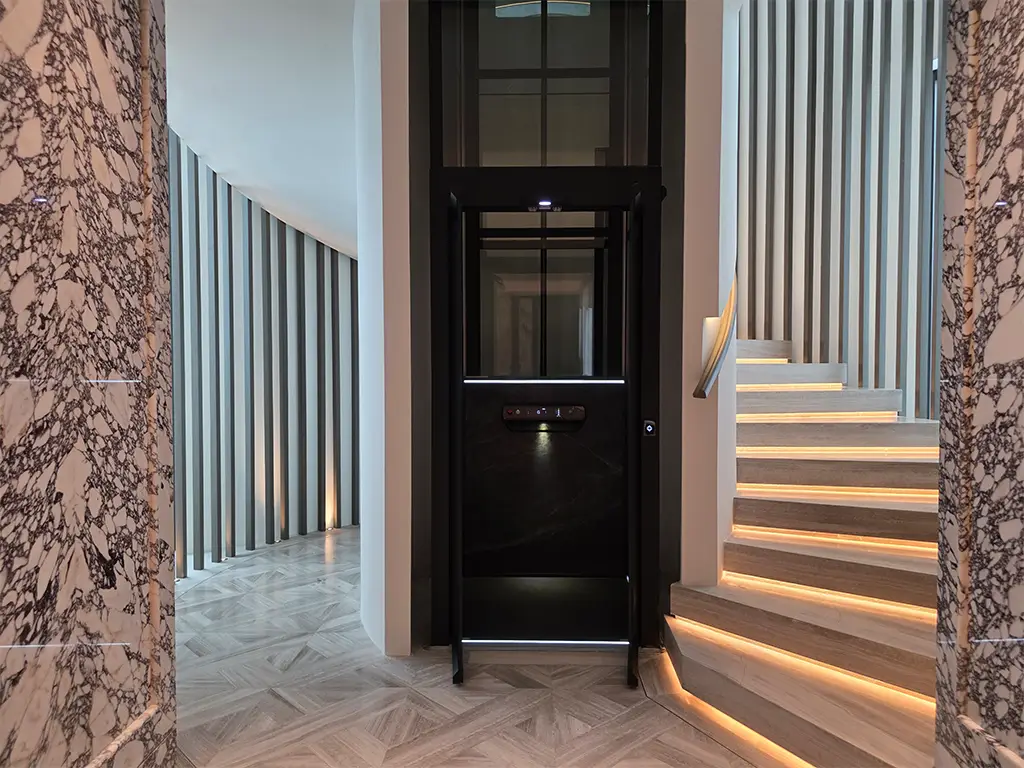 Cibes V80 Aurora 2-stop home lift installed beside an illuminated staircase inside a luxury Dubai villa.